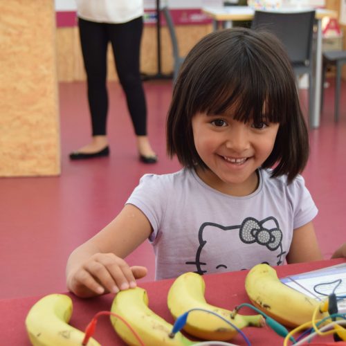 Niña creando un piano de plátanos